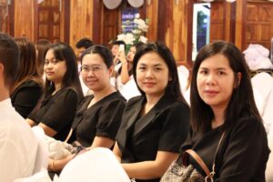 สถาบันวิจัยฯ ร่วมพิธีบำเพ็ญกุศล: ผู้หญิงสวมชุดดำนั่งในงานพิธี สวพ. มร.เพชรบูรณ์