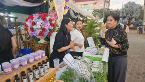 สวพ.มรภ.เพชรบูรณ์ จัดนิทรรศการมะขามหวานเพชรบูรณ์ปี 2569: ผู้หญิงสามคนยืนอยู่ที่บูธขายสินค้า สวพ. มร.เพชรบูรณ์