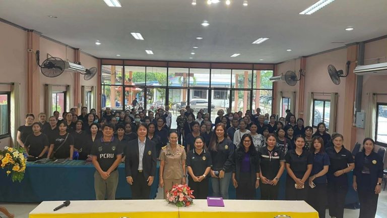 กลุ่มคนยืนถ่ายรูปในห้องประชุม โดยมีผู้หญิงสวมชุดพนักงานสีดำและชุดข้าราชการยืนอยู่แถวหน้า สวพ.มร.เพชรบูรณ์
